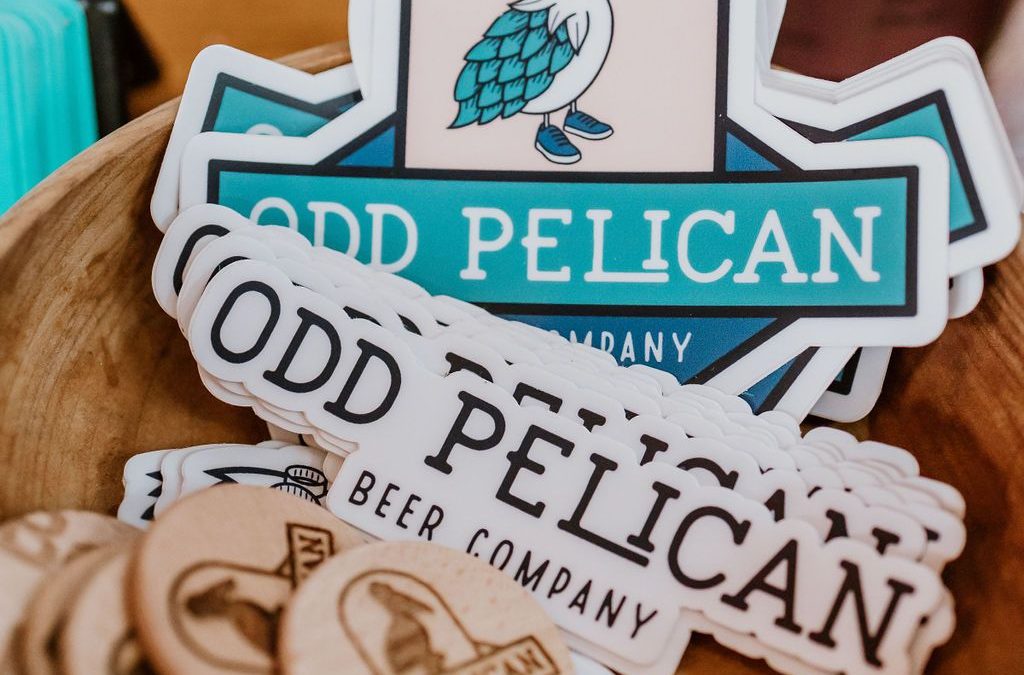 A picture of stickers and other swag with The Odd Pelican Logo.